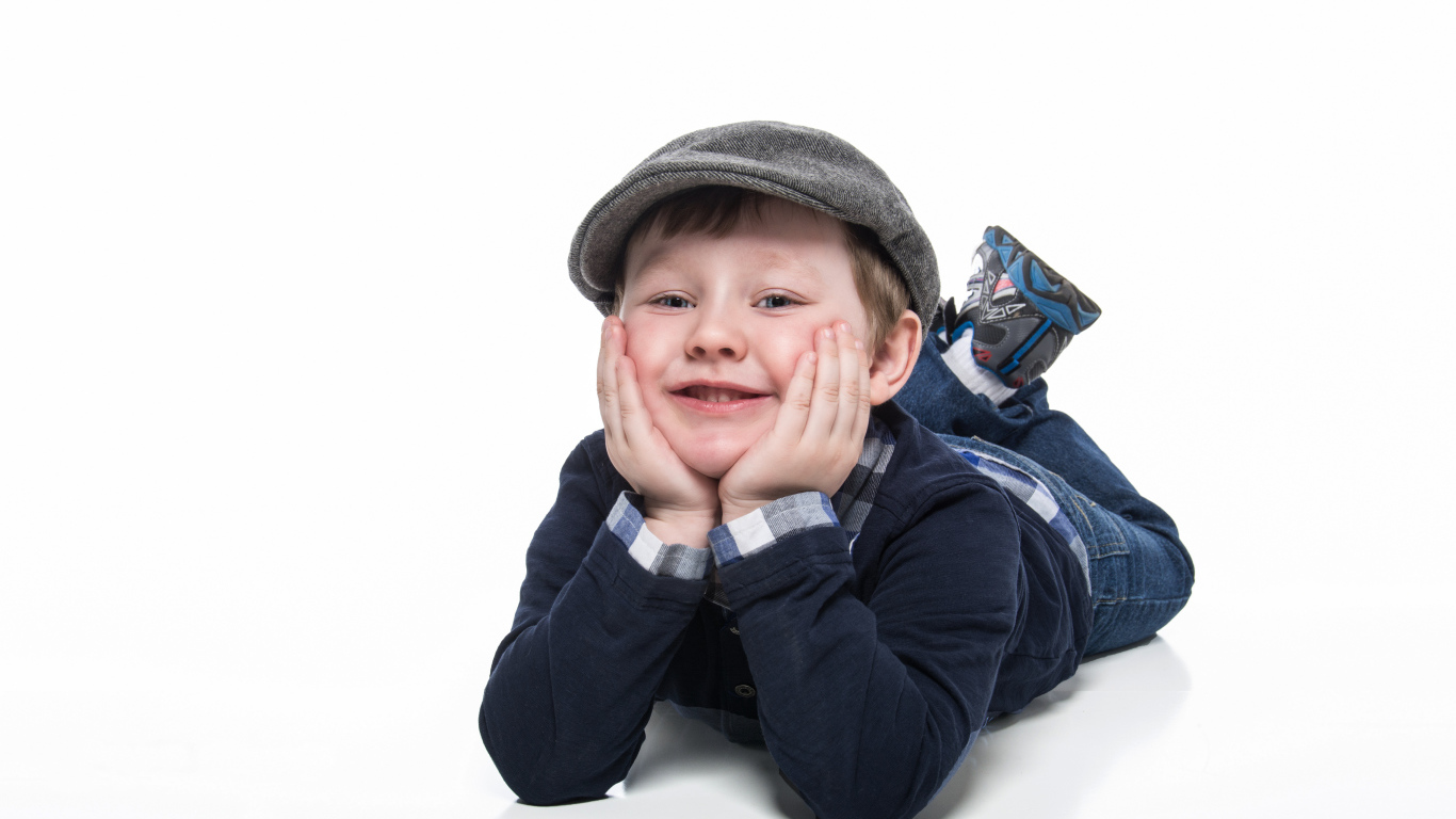 Маленький милый мальчик в кепке на белом фоне