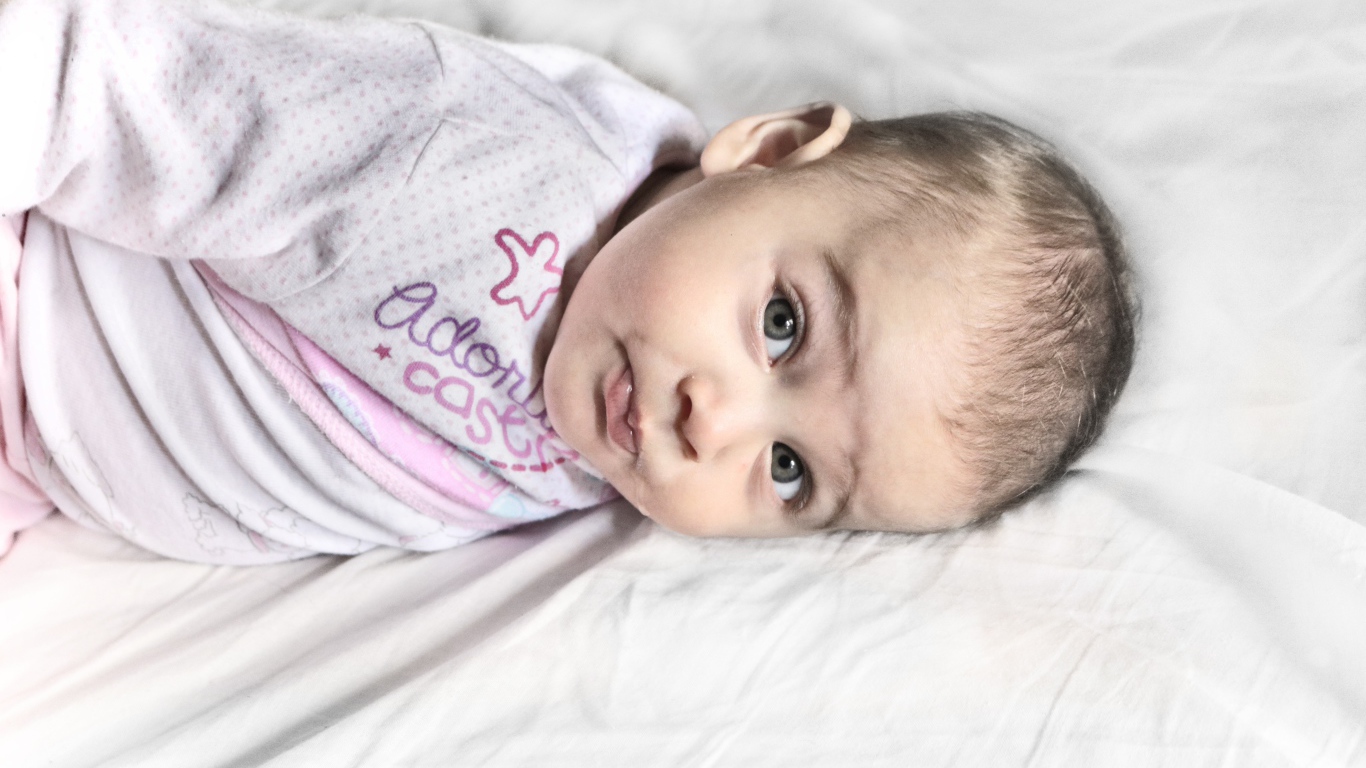 Маленький новорожденный ребенок лежит на кровати 