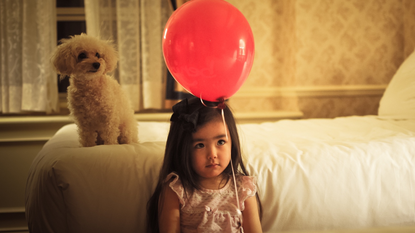 Грустная девочка азиатка с красным шариком