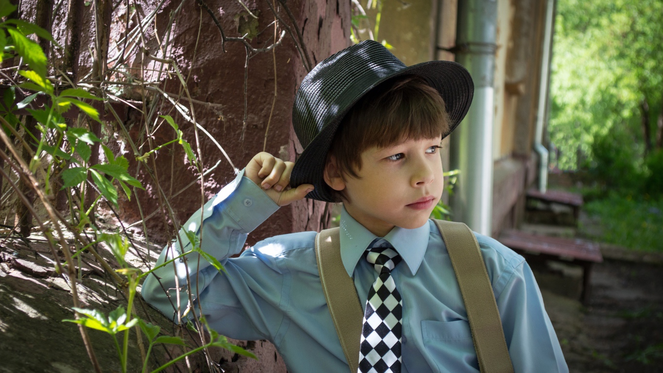 Стильный мальчик в черной шляпе 