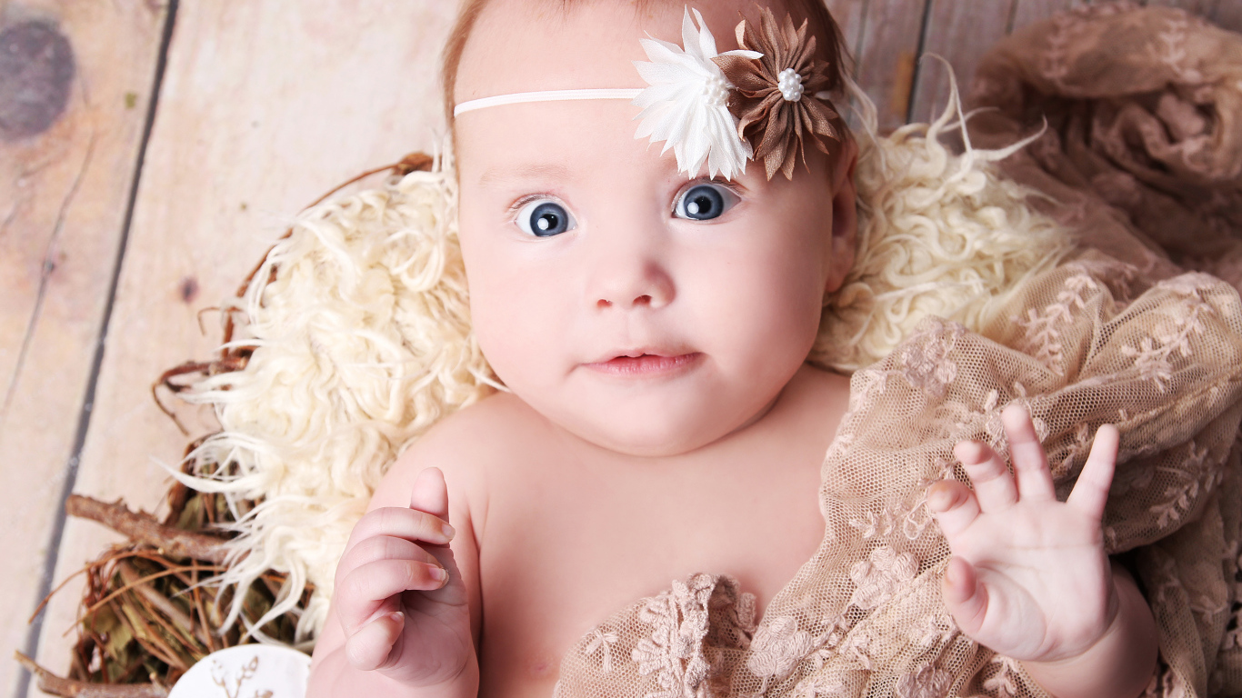 Удивленная голубоглазая новорожденная девочка 