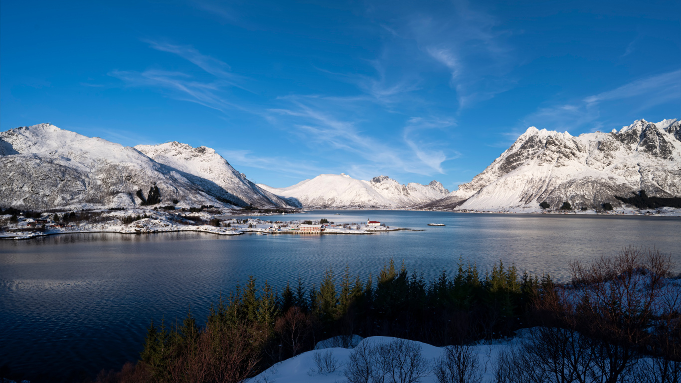 Покрытые снегом горы под голубым небом у воды, Норвегия
