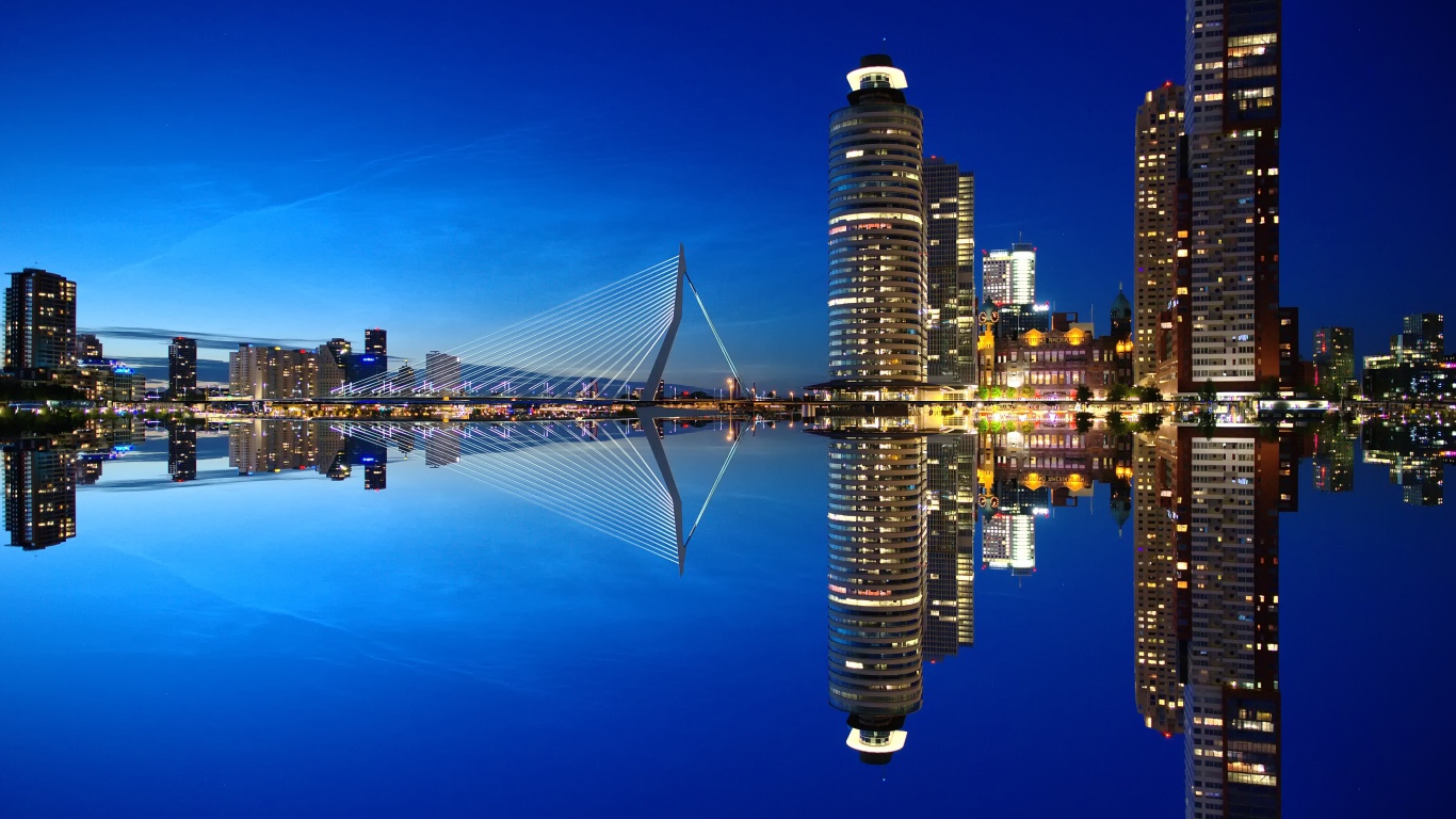 Небоскребы и мост отражаются в тихой воде