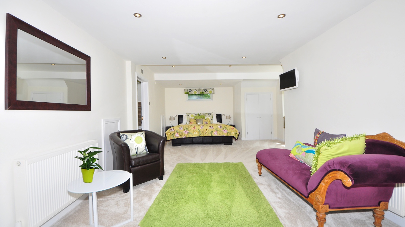 Большая гостиная с высокими белыми стенами и мебелью 