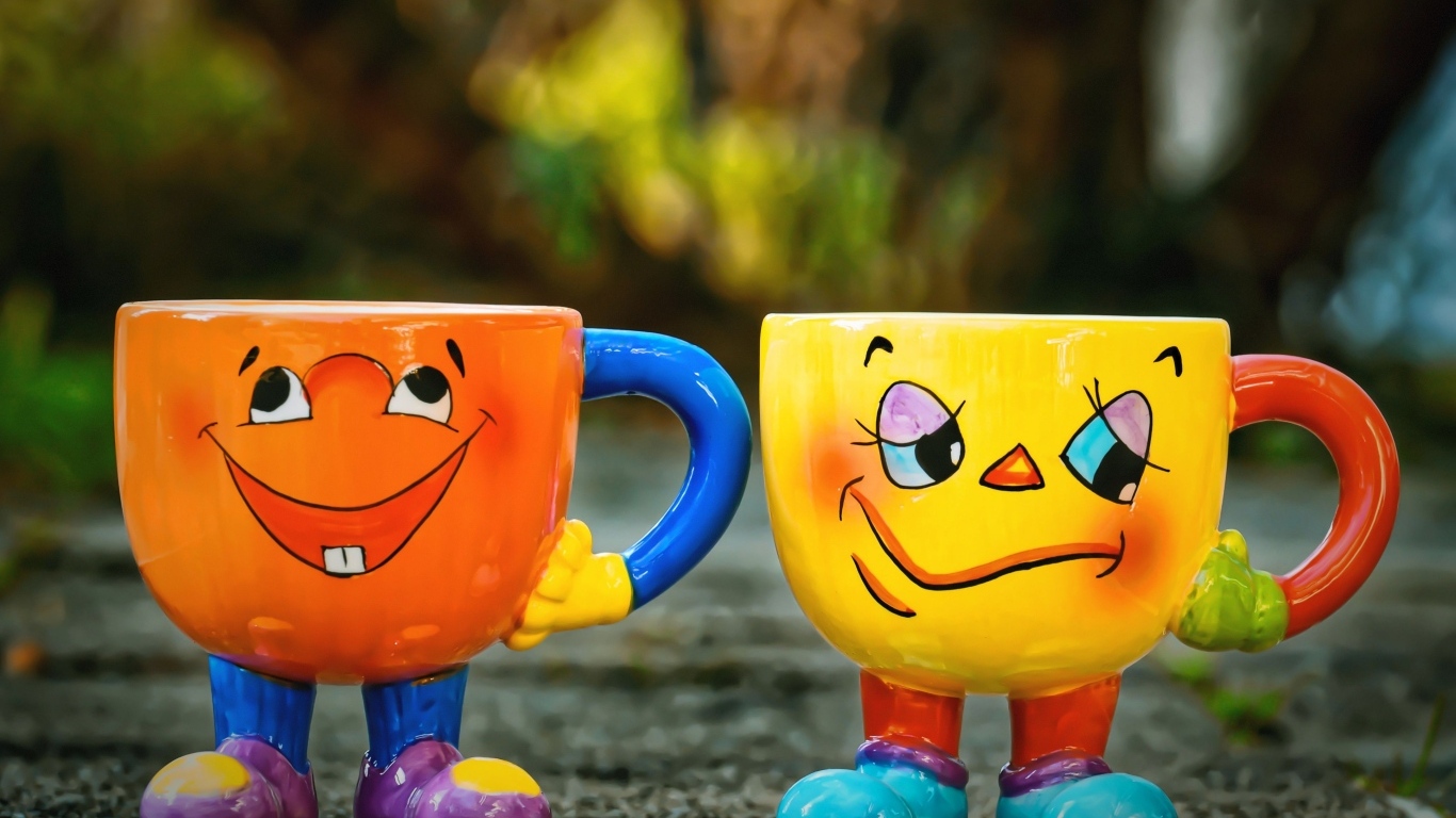 Cheerful and sad cups stand on the asphalt