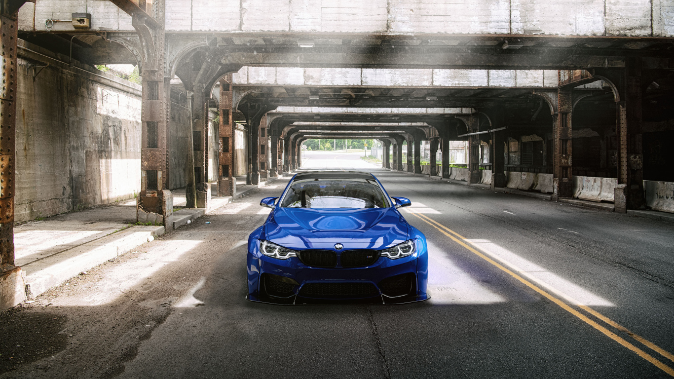Синий автомобиль BMW M4 под мостом