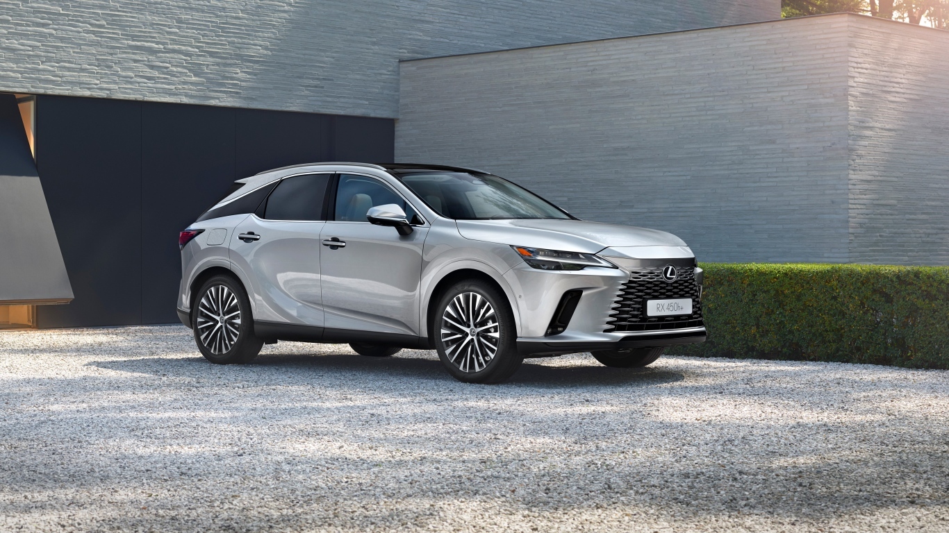 Серебристый внедорожник Lexus RX 450h+ у здания
