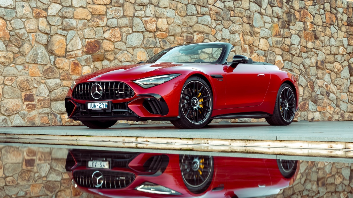 Красный Mercedes-AMG SL 63 4MATIC+ 2023 года на фоне стены