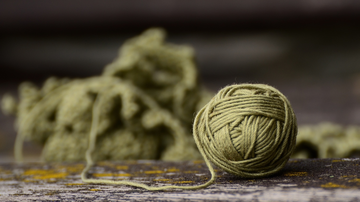 Клубок ниток на деревянном столе