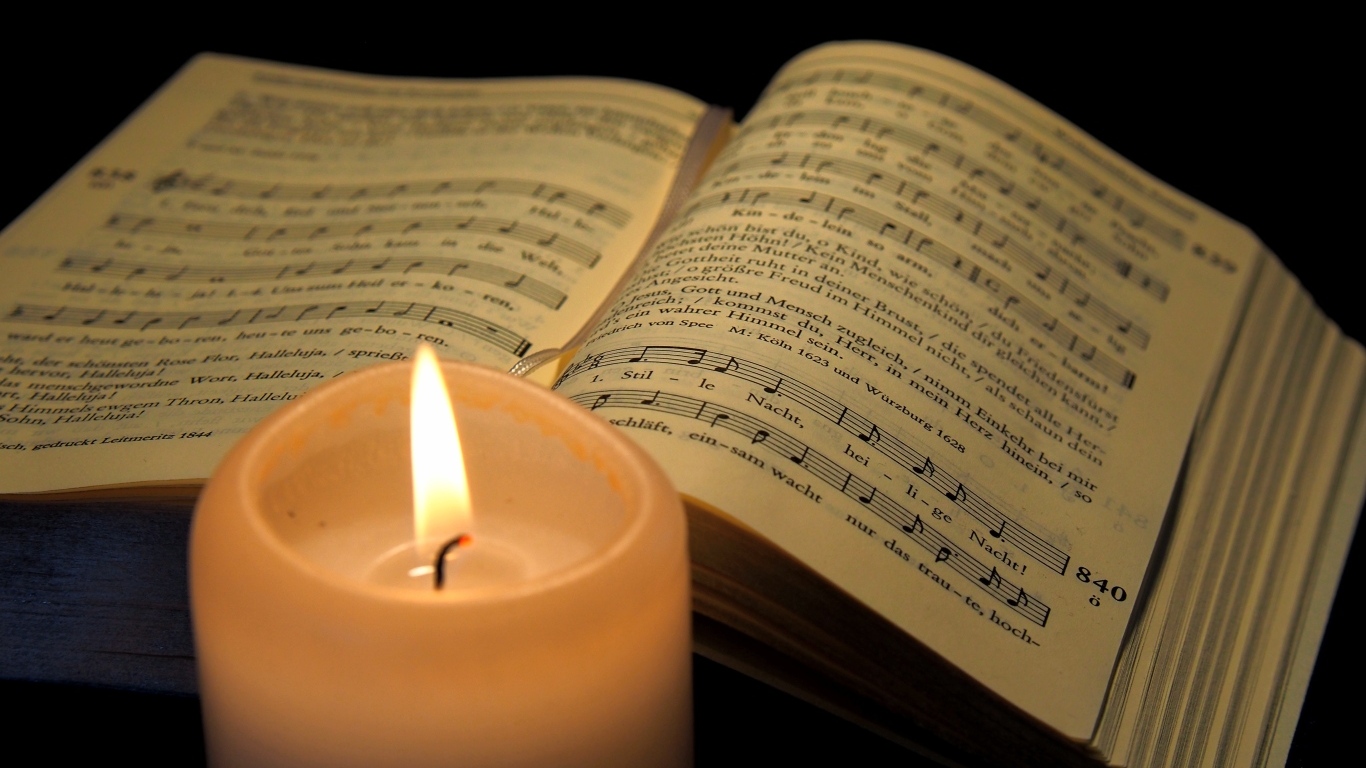 Зажженная свеча с книгой с нотами
