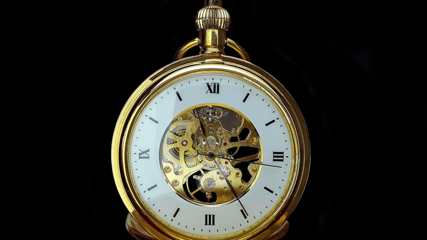 Старинные золотые карманные часы на черном фоне