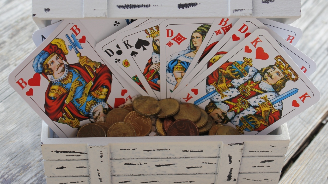 Колода карт и монеты в деревянной шкатулке