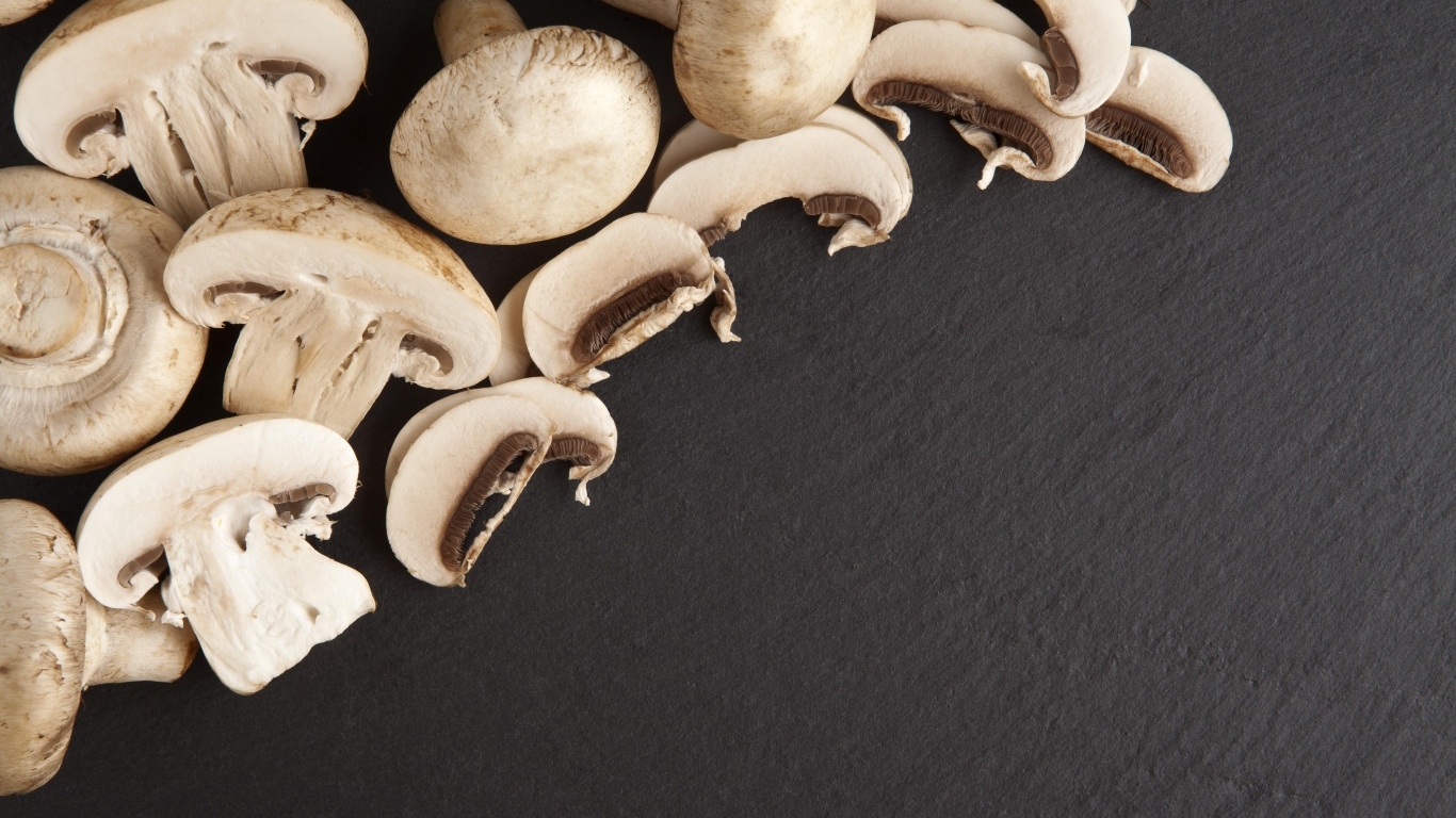 Аппетитные свежие шампиньоны на сером столе