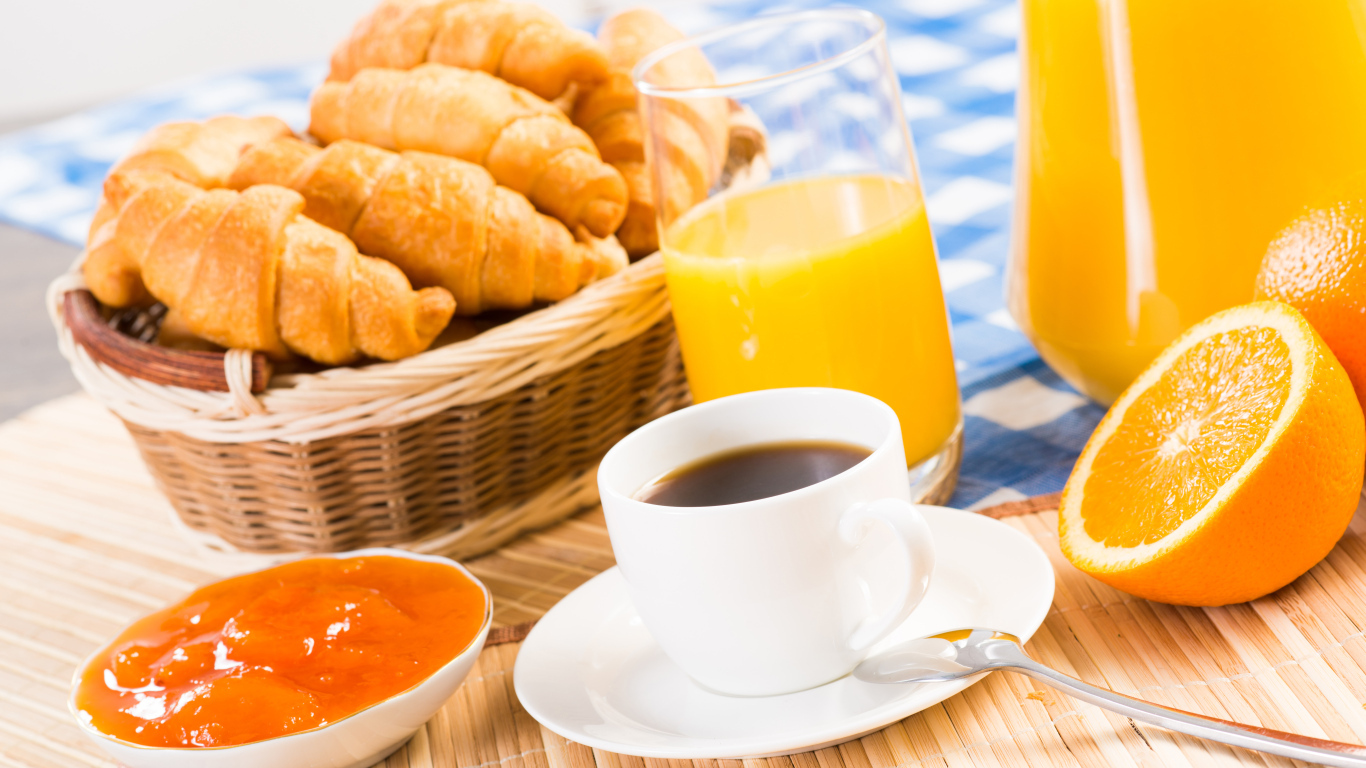 Кофе с круассанами и соком на столе на завтрак