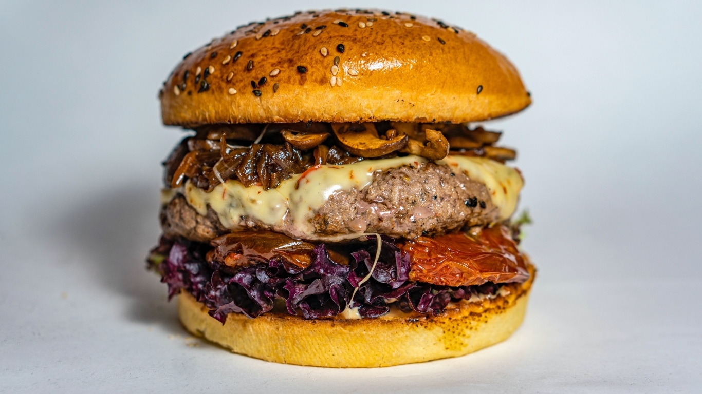 Ароматный сочный гамбургер на сером фоне крупным планом