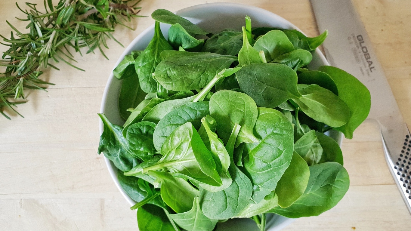 Зеленые листья базилика на столе с розмарином