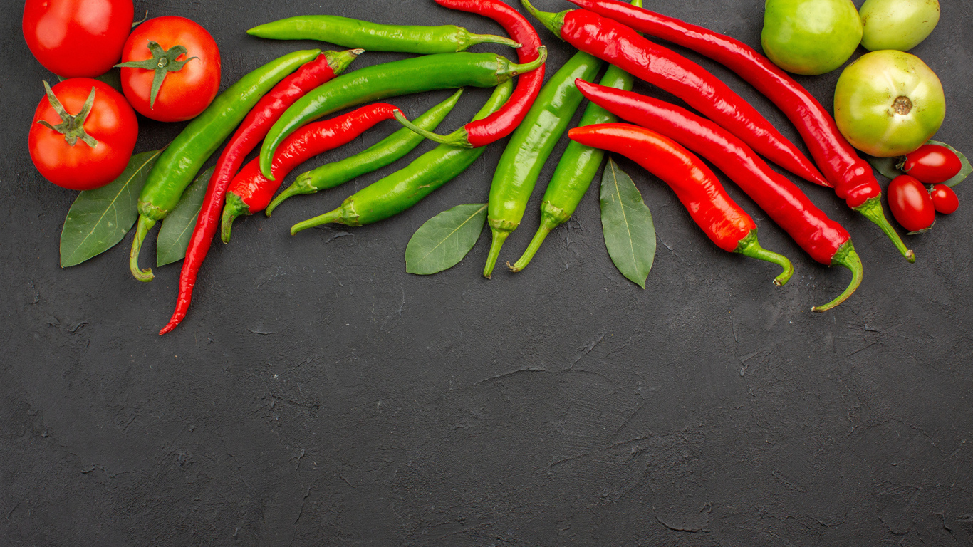 Острый перец чили на столе с помидорами