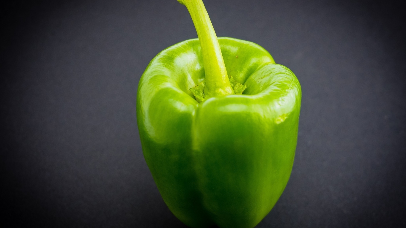 Большой зеленый перец на сером  фоне