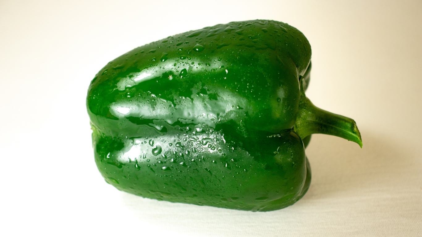 Крупный зеленый перец на белом фоне
