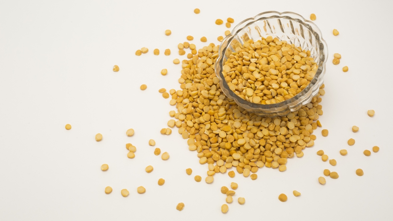 Чечевица рассыпана на белом фоне