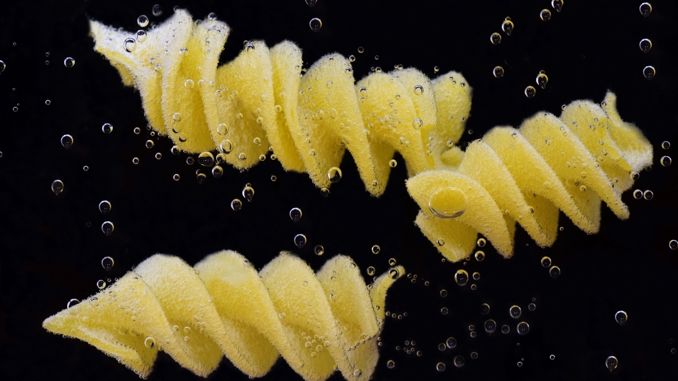 Макароны в воде на черном фоне