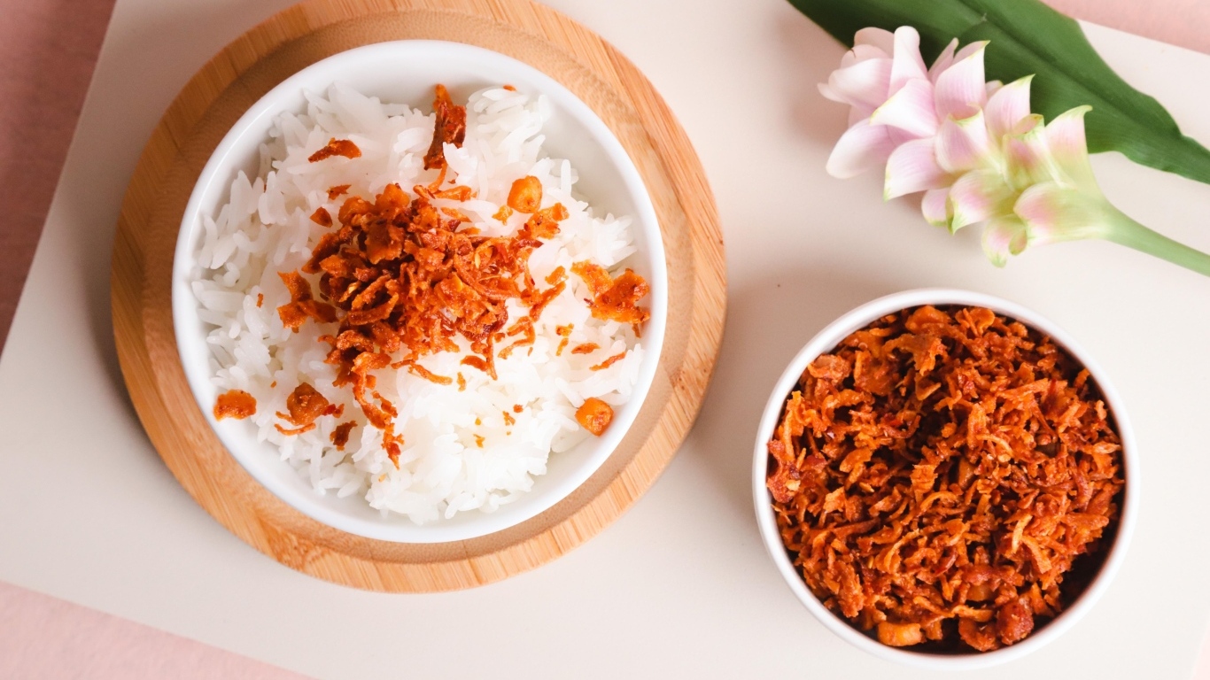 Рис с луком на столе с цветком