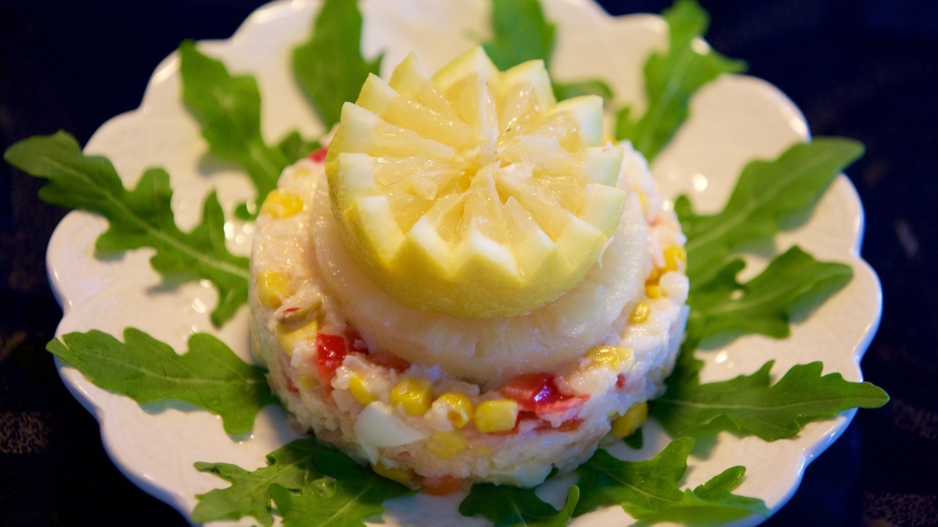 Салат на тарелке с лимоном и рукколой