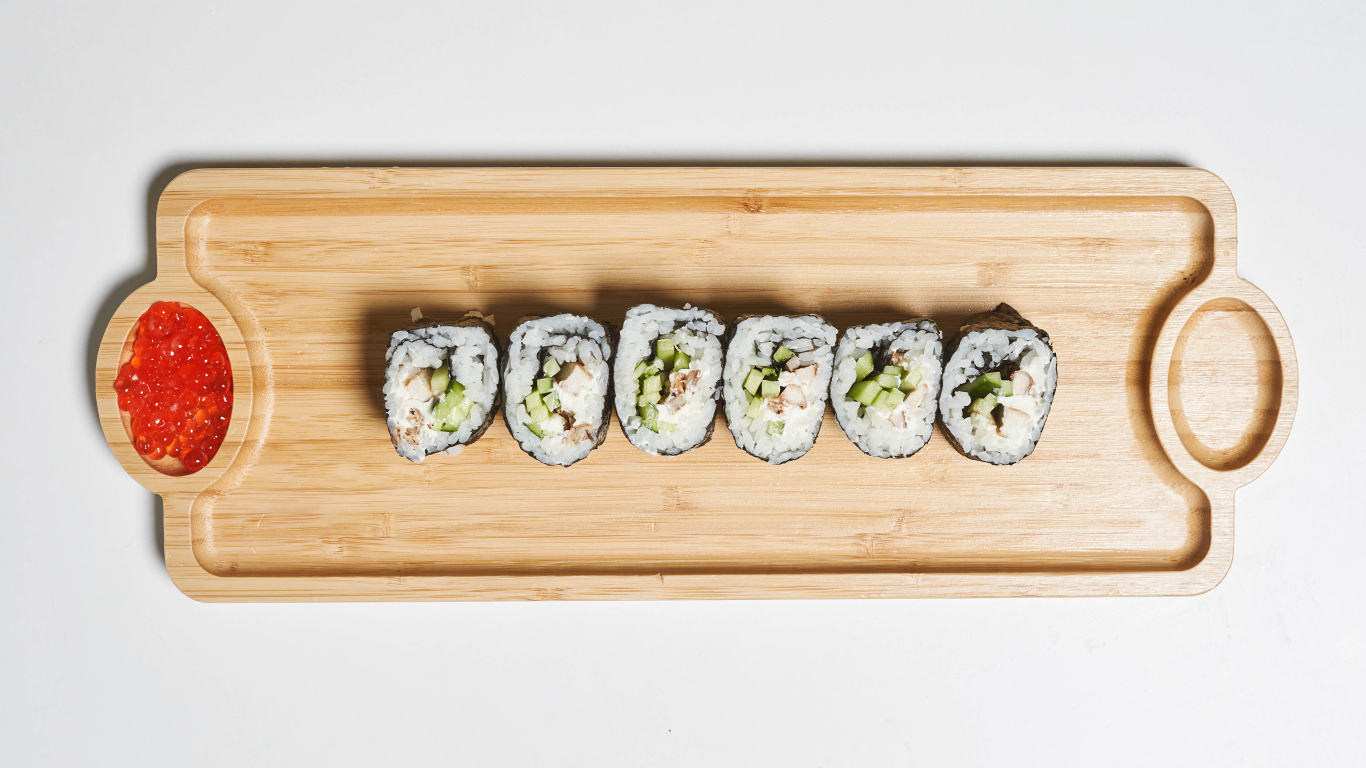 Суши на деревянной доске с  красной икрой