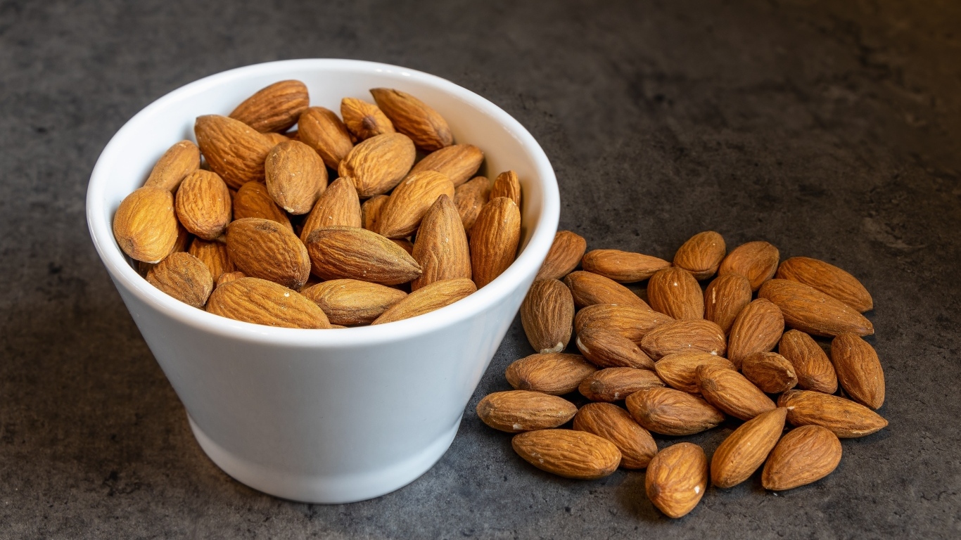 Миндальные орехи в белой пиале на столе