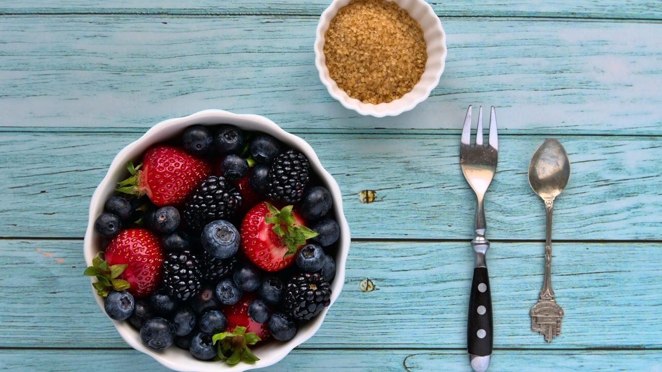 Аппетитные спелые ягоды в тарелке на столе