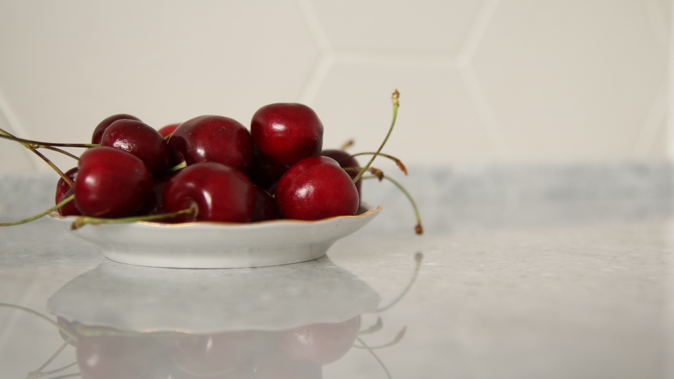 Вкусные сладкие черешни на белой тарелке