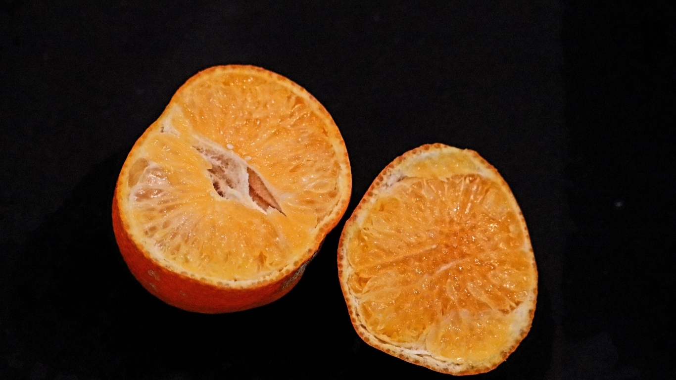 Мандарин на черном фоне крупным планом