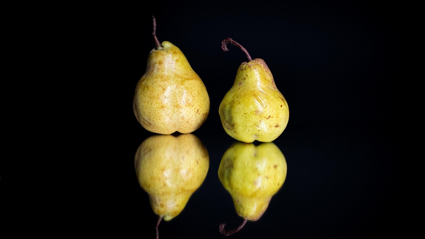 Две груши отражаются в зеркальной поверхности 