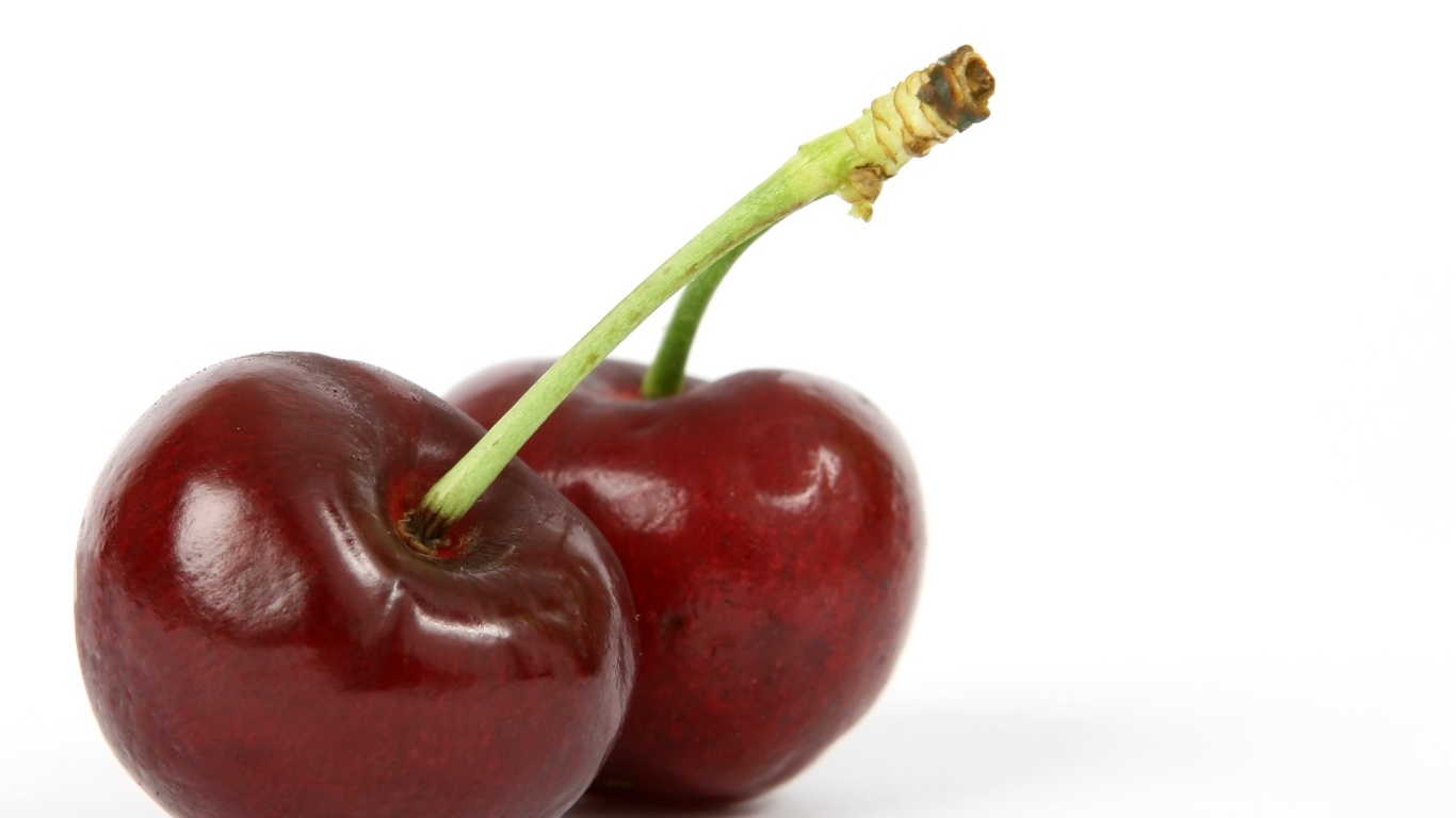 Две красные ягоды черешни на белом фоне