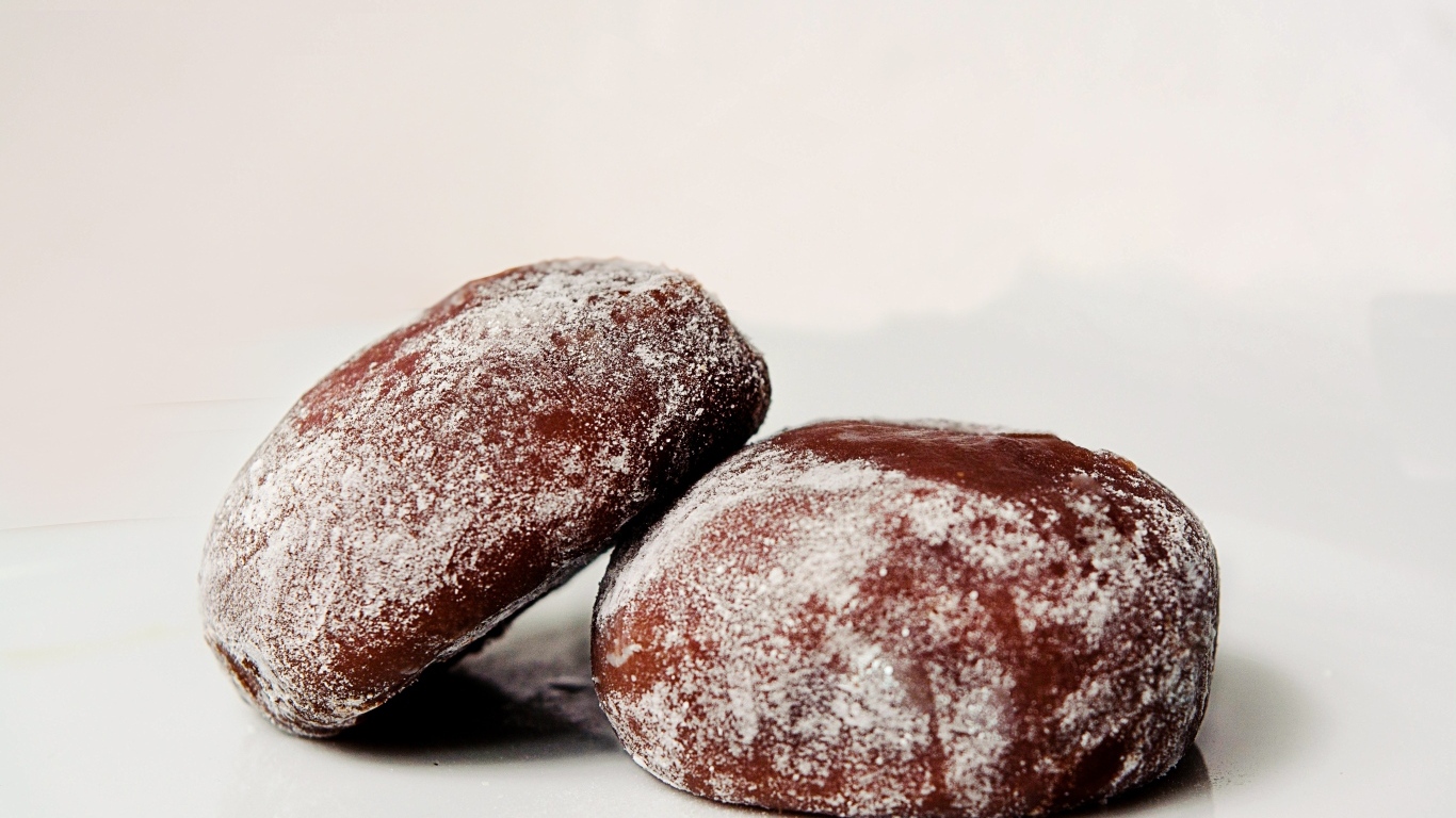 Две буханки ржаного хлеба на сером фоне