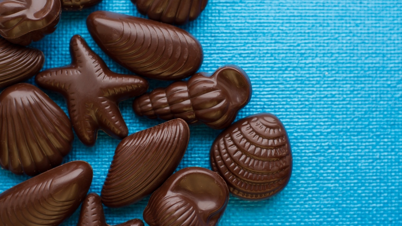 Шоколадные конфеты в форме ракушек на голубом фоне