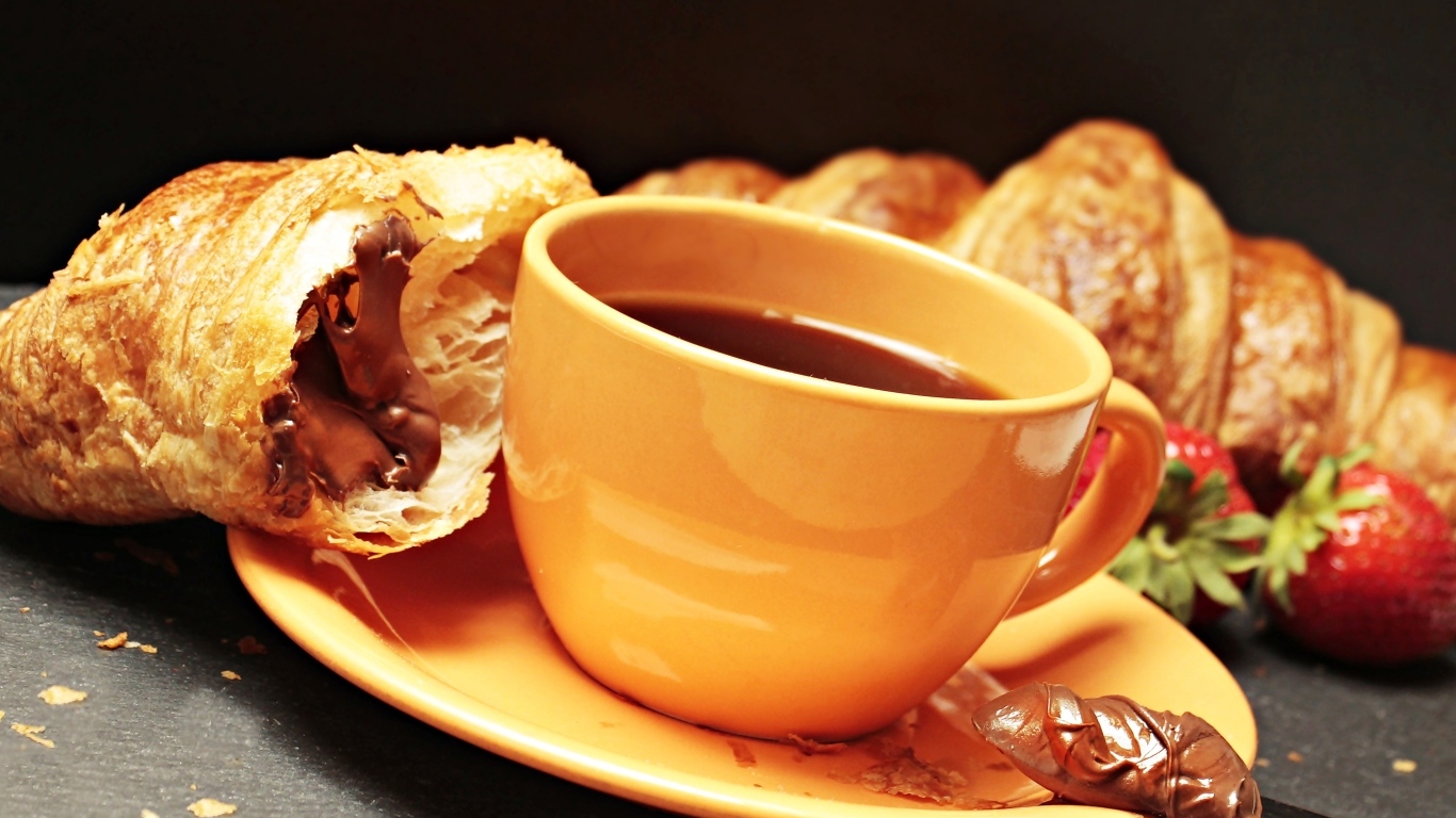 Чашка кофе на тарелке с круассанами