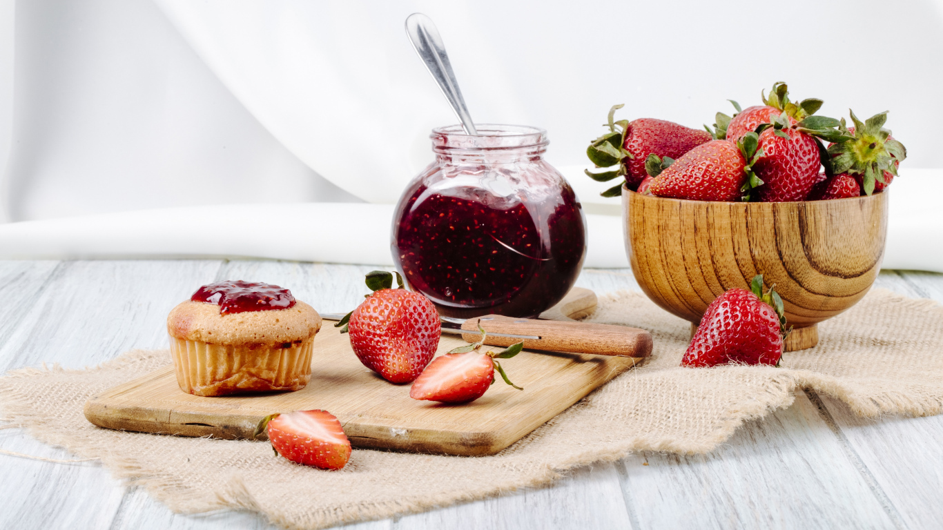 Кекс со свежей клубникой и джемом на столе