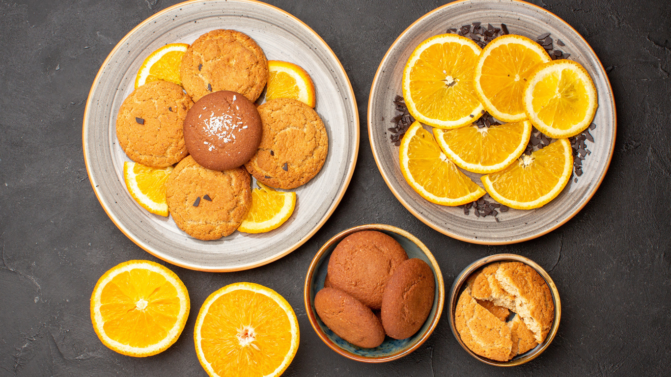 Вкусное печенье на тарелке с апельсинами