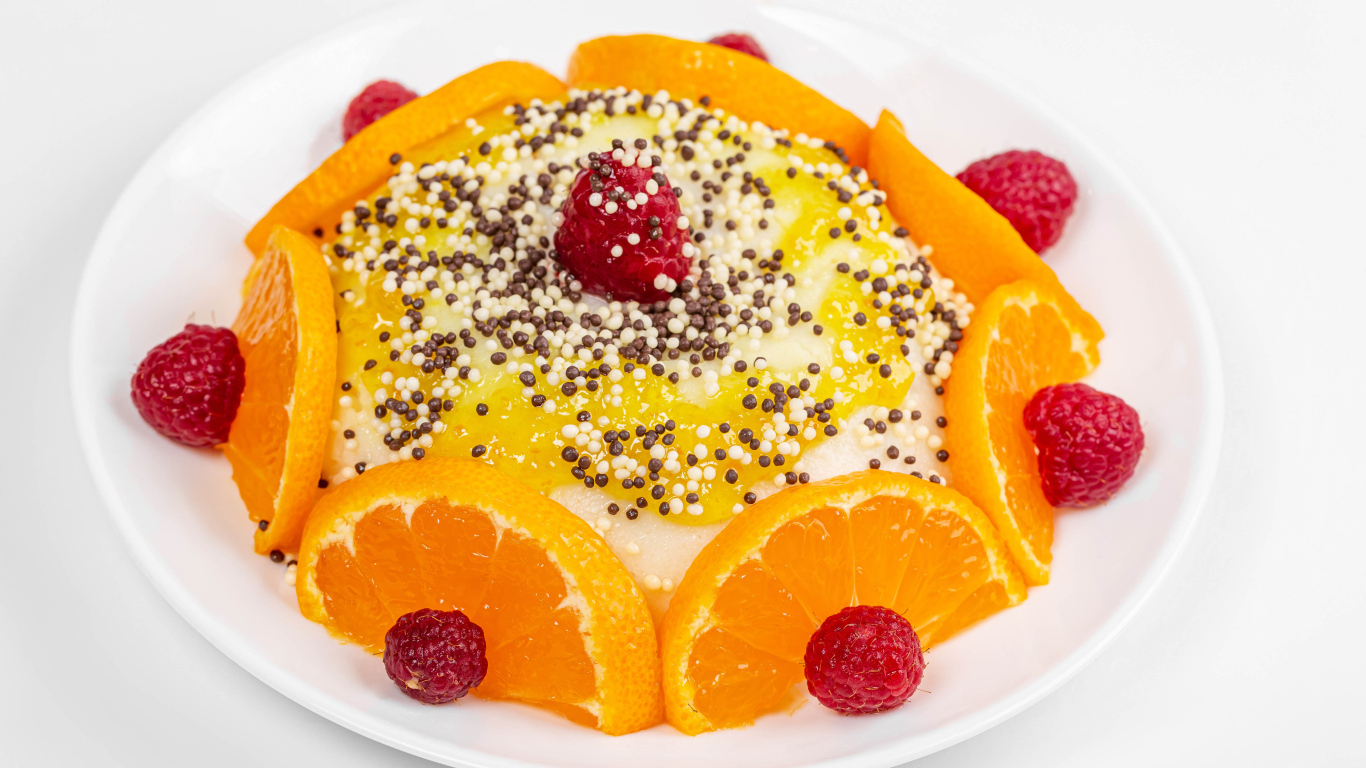 Десерт с кусочками апельсина и ягодами малины на белом фоне