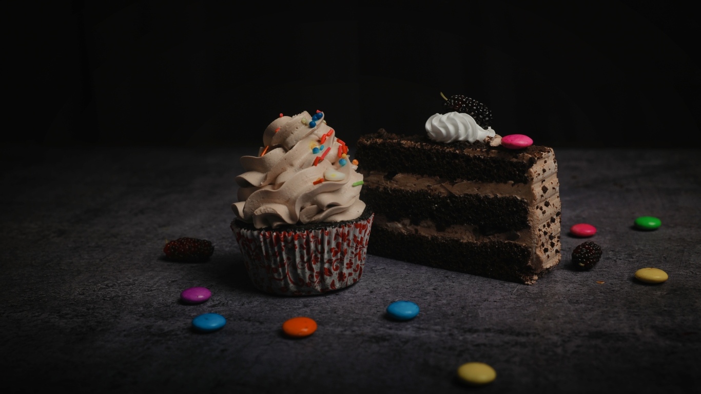 Кусок торта и кекс с кремом на столе