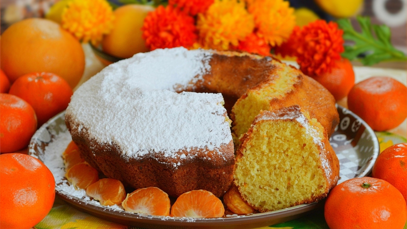 Сладкий пирог на столе с мандаринами и апельсинами