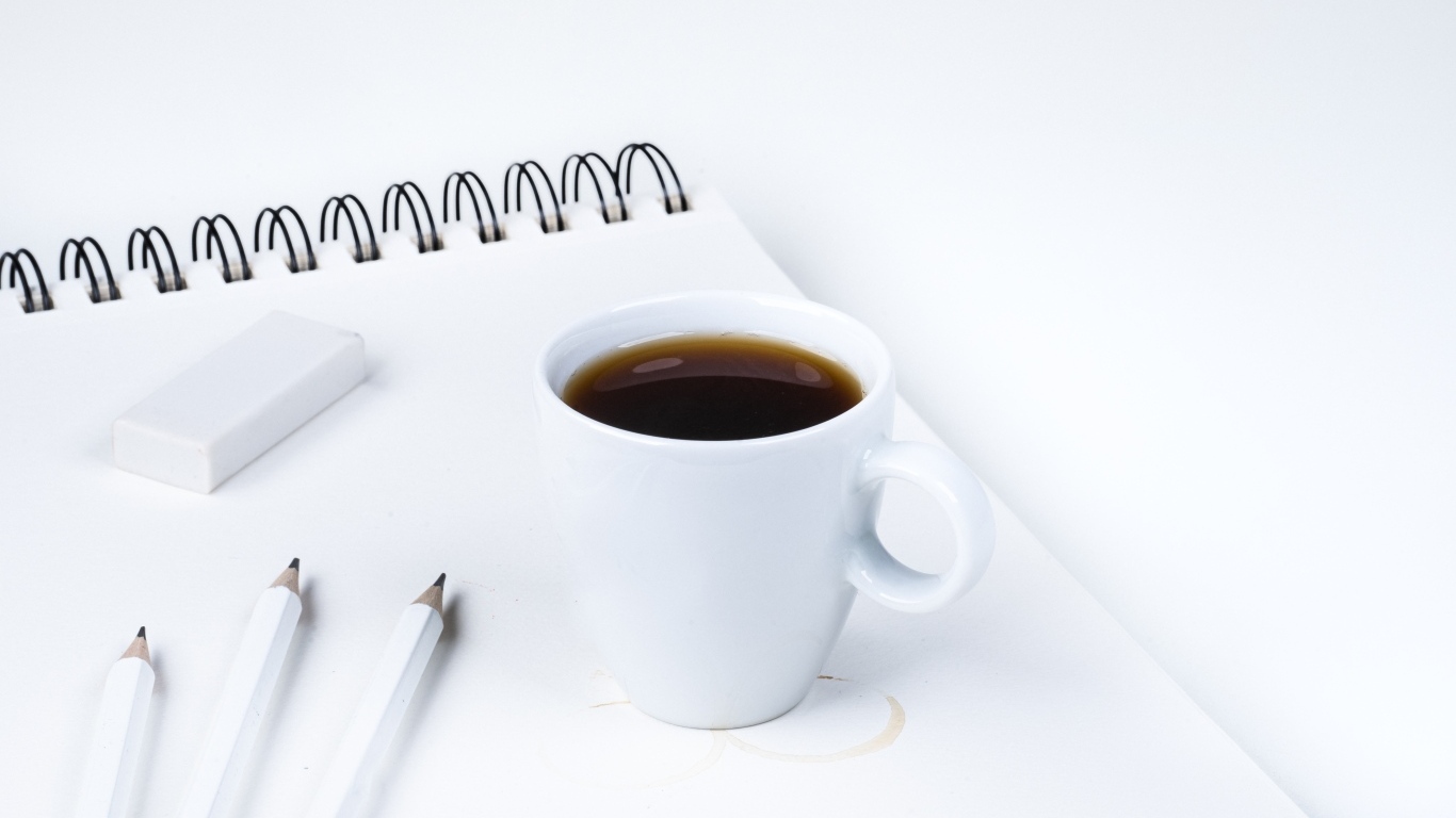 Чашка ароматного кофе с блокнотом на столе