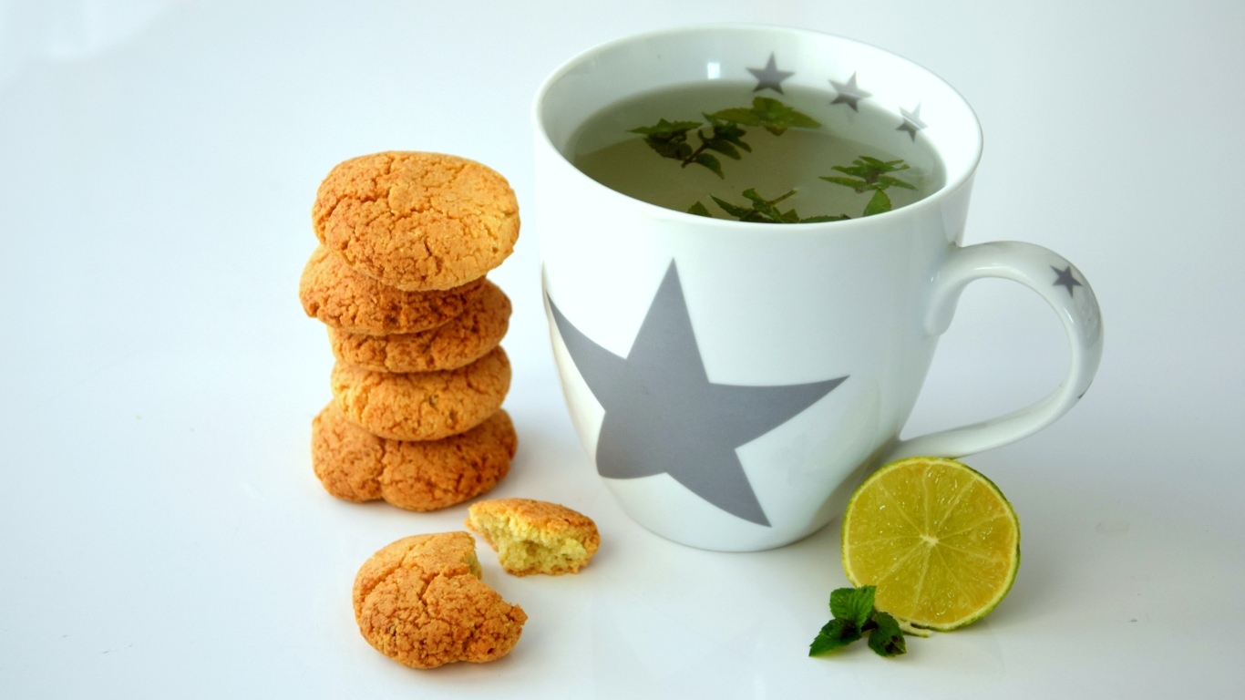 Чашка чая на столе с лимоном и печеньем
