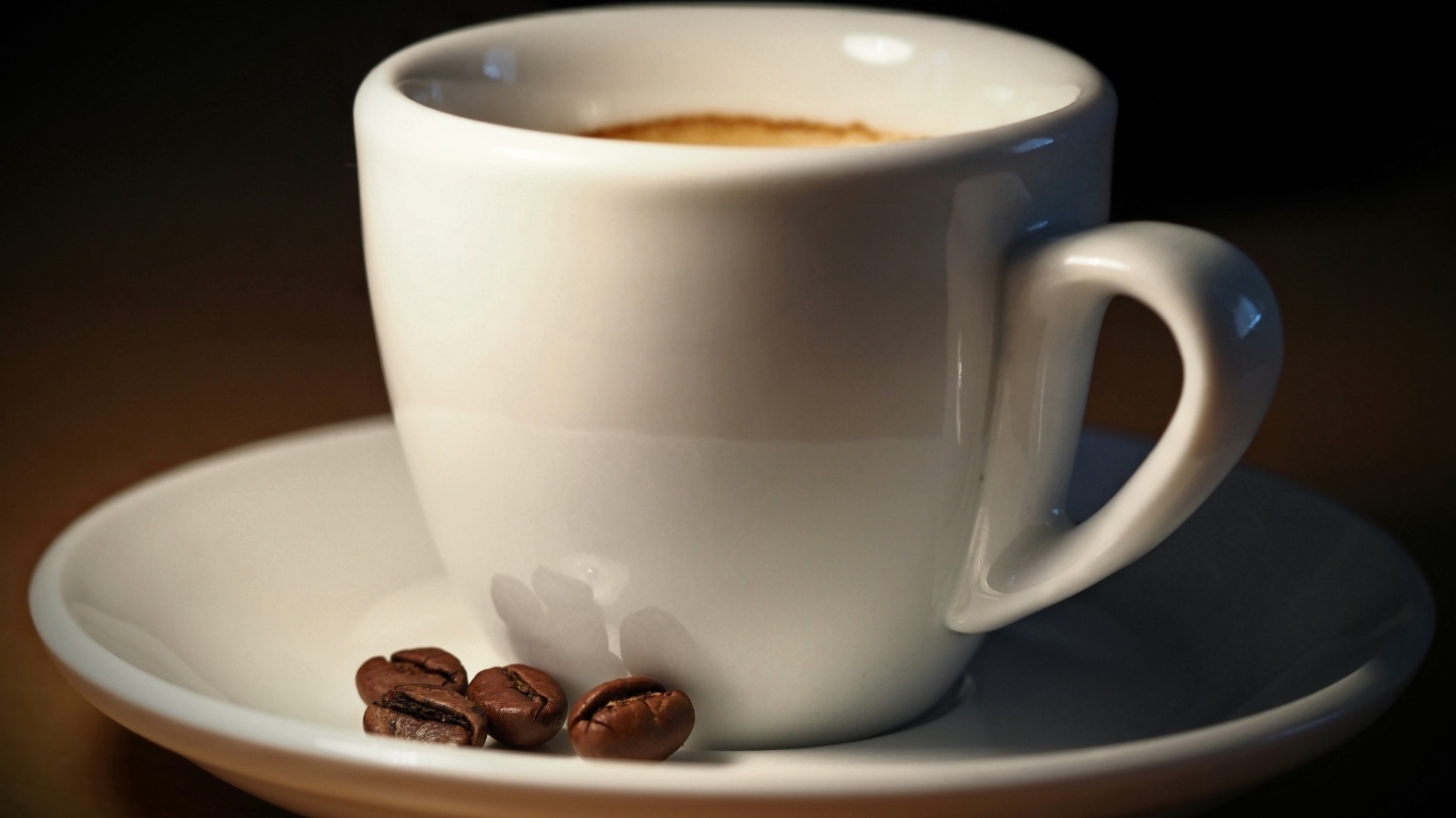 Белая чашка кофе с зернами крупным планом