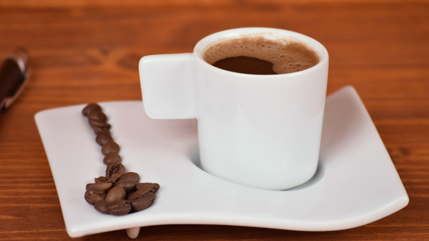 Белая чашка горячего кофе на столе 