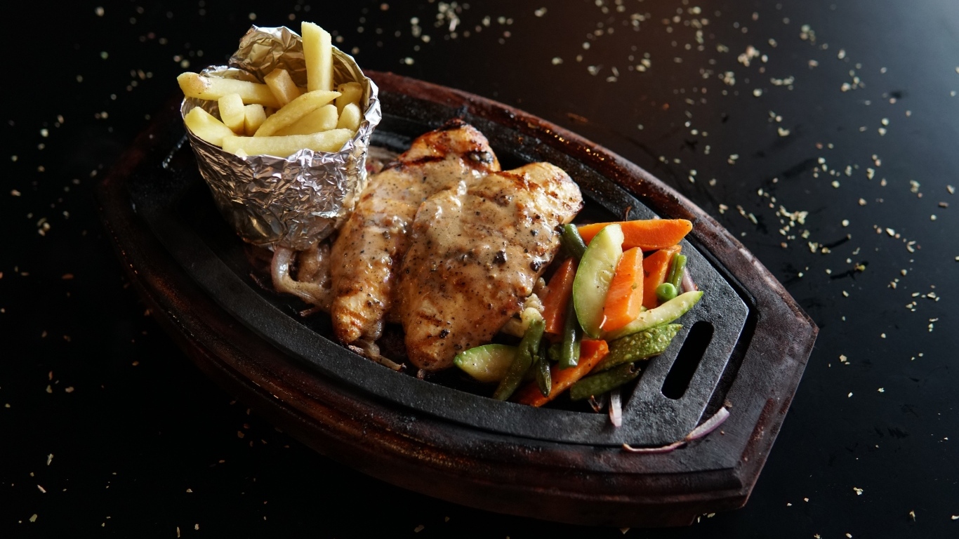 Жареная курица с картофелем фри и салатом на тарелке