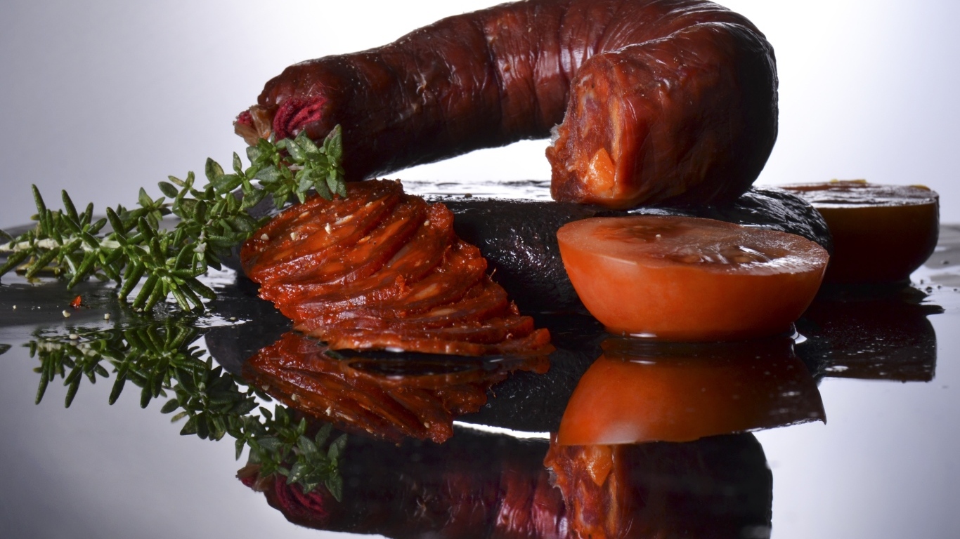 Колбаса с помидорами на зеркальном столе