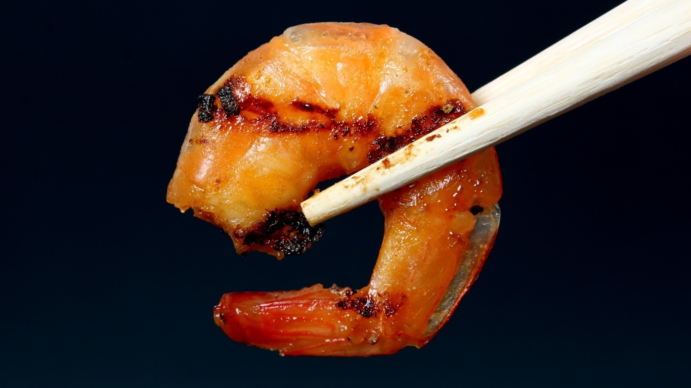 Жареная креветка с палочками на черном фоне