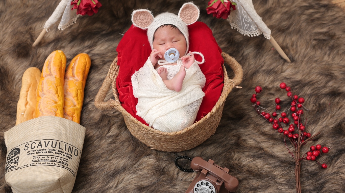 Ребенок спит в корзине с соской во рту